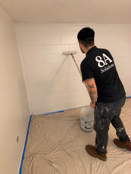 8A rolling fresh paint across a wall